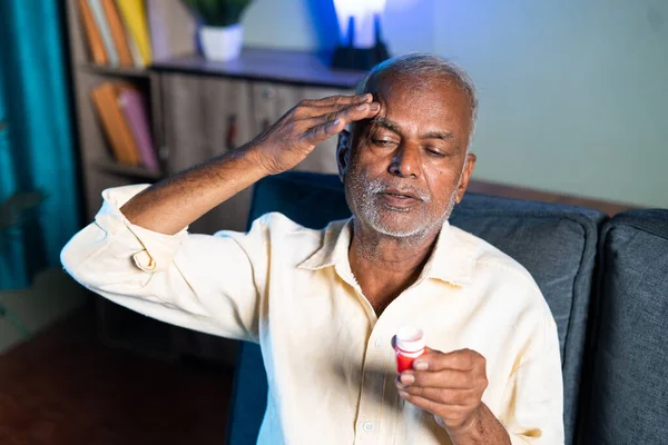 Senior man using pain relief balm for headache - concept of massage ointment for migraine, stress relief and painkiller. — Stockfoto