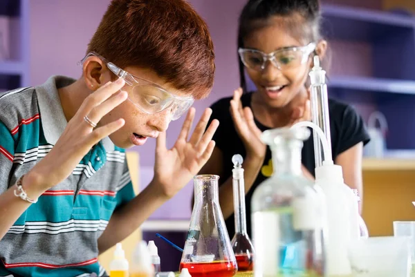 Surprised Kid over science experiment result or chemical reaction at chemistry laboratory - concept of childhood excitement, learning new skills and education. — Stock Photo, Image