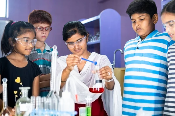 Pan shot of Teacher Explaining about science experiment to students with Eye Protection Glasses at chemistry laboratory - Concept of Education, workshop and Teaching — Stock Photo, Image
