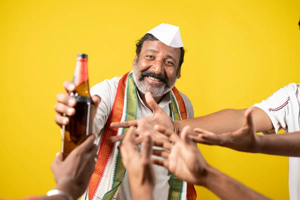 Corrupt indian politician distributing alcohol or liquor to people during by poll election - concept of voter manipulation, corruption or bribe and political strategies to will polls — Stock Photo, Image