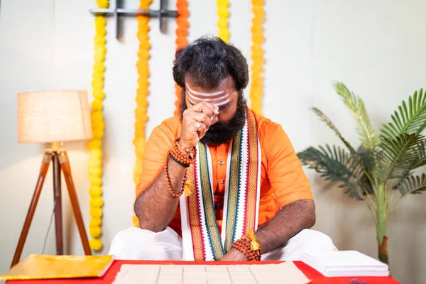 Indický svatý guru modlící se bůh tím, že drží skořápky cowrie zpěvem chvalozpěvy v klášteře - koncept astrologa, indické kultury a věštkyně. — Stock fotografie
