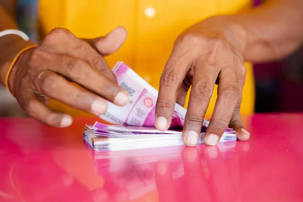 Closeup of hands counting money or currency notes on table - concept of tax savings, business profits, finance and banking. — Stockfoto