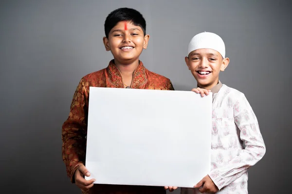 Szczęśliwy indiański wielonarodowe dzieci pokazując pusty tablicy znamionowej patrząc w aparat - koncepcja przyjaźni, reklamy i religijnych więzi i promocji. — Zdjęcie stockowe