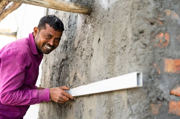 Felice costruzione sorridente lavoro livellamento muro intonaco utilizzando strumento di legno sul posto di lavoro concetto di duro lavoro, manodopera qualificata e stile di vita scommesse quotidiane — Foto Stock