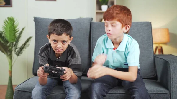 Triste adolescente niño pidiendo juego pad a su hermano en casa - concpet de hermanos multiétnicos, adicción a los videojuegos y entretenimiento. — Foto de Stock