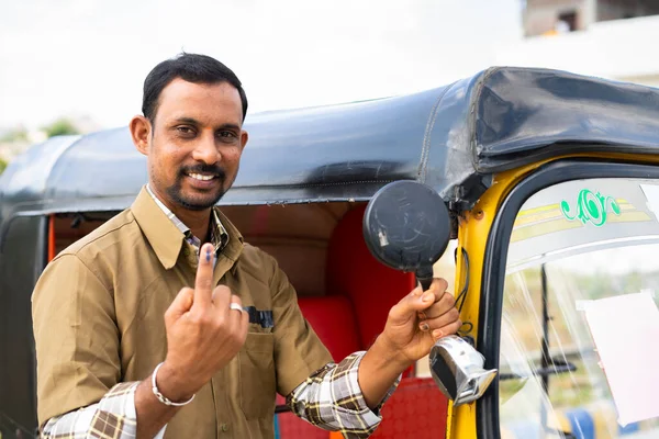 Skup się na Finger, Smiling auto driver showing Ink marked finger after vote in election by looking at camera - concept of democracy, Indian election and responsibility — Zdjęcie stockowe
