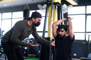 Spor salonundaki spor salonu eğitmenlerine odaklanın. Spor salonundaki dambılları kaldırmaya yönelik eğitim ya da tıbbi yüz eğitimi alan spor eğitmenlerine. Kovid-19 ya da koronavirüs salgını sırasında