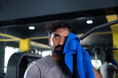 Sıkı çalışan Hintli genç vücut geliştiricinin spor salonunda ağır egzersizden sonra terleyerek rahatladığı yakın plan fotoğrafı - konsept sağlıklı yaşam tarzı, vücut geliştirme, rahatlama ve fitness ilham kaynağı.