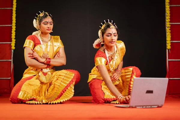 Bharatnatyam dansers bezig met het controleren van stappen op laptop tijdens het dansen podium - concept van technologie, repetitie, voorbereiding en leren van online — Stockfoto