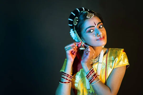 Danseuse indienne bharatanatyam portant des boucles d'oreilles en regardant la caméra sur scène concept de préparation, culture indienne et traditionnelle. — Photo