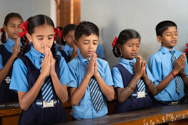 Οι μαθητές στην τάξη κάνουν πρωινή προσευχή με κλειστά μάτια - έννοια της σοφίας, της φιλίας, της ανάπτυξης και της πειθαρχίας. — Φωτογραφία Αρχείου