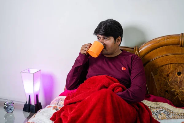 Jeune homme buvant du mauvais café le matin en s'asseyant sur la chambre concept de routine quotidienne, de rafraîchissement et d'autosoin. — Photo