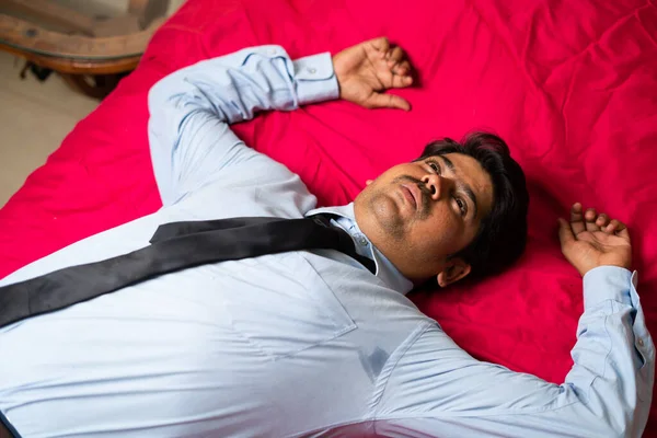 Vue d'ensemble du jeune homme d'affaires fatigué tombant sur le lit après son arrivée du bureau concept de surmenage, de stress et de détente. — Photo