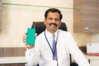 cep telefonuna odaklan, yeşil ekran cep telefonu gösteren gülümseyen şirket çalışanı kameraya bakarak - reklam, uygulama ve ürün promosyonları kavramı