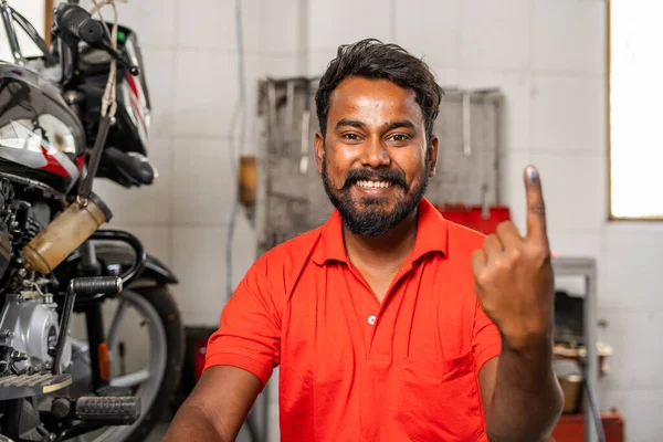 Szczęśliwy uśmiechnięty mechanik pokazujący atrament oznaczony palcem wyborcy po oddaniu głosu w wyborach - koncepcja odpowiedzialności, demokracji i prawa — Zdjęcie stockowe