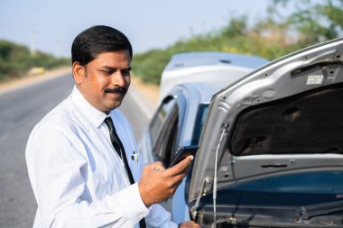İş adamı, arızalı araba konsepti, online rezervasyon ve mobil hizmet konsepti önünde çevrimiçi yardım veya cep telefonu tamir hizmetleri için rezervasyon yaptıktan sonra mutlu oldu.