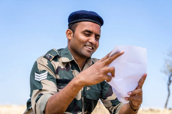 Tineri soldați indieni care citesc scrisori sau corespondență de la un membru al familiei în timp ce se află la serviciu pe partea de sus a muntelui - conceptul de familie dispărută, legătură și comunicare îndepărtată — Fotografie, imagine de stoc