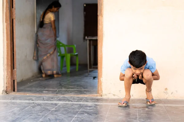 Παιδί κάθεται έξω από το calss κρατώντας τα αυτιά ως τιμωρία - έννοια της παιδικής κακίας και της εκπαίδευσης και μάθησης — Φωτογραφία Αρχείου