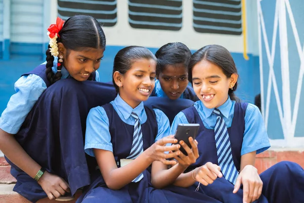 Group of smiling girl kids busy using mobile phone at school corridor during break - concpet of smartphone addiction, using social media and technology — Stock Photo, Image