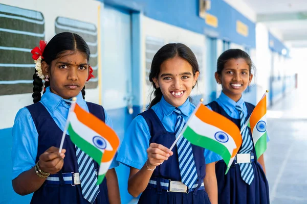 Χαμογελώντας κορίτσι kis στο unifrom κουνώντας ινδικό γεράκι κοιτάζοντας κάμερα στο σχολικό διάδρομο - έννοια του πατριωτισμού, δημοκρατία ή γιορτή ημέρα ανεξαρτησίας — Φωτογραφία Αρχείου