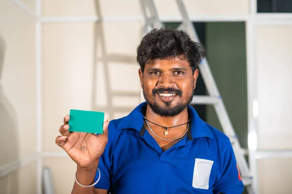 Lavoratore che mostra la carta verde guardando la macchina fotografica in cantiere concetto di ID dipendente, servizio di manutenzione o ristrutturazione e promozione. — Foto Stock