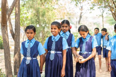 Okul bahçesine giderken el ele tutuşan bir grup genç çocuk. Arkadaşlık kavramı, ara vermek ve sosyalleşmek..