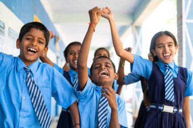 Bir grup neşeli öğrenci tatil nedeniyle okul koridorunda kamerayla bağırıyor - özgürlük, eğlence ve rahatlama bağrışmaları