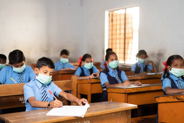 Çocukların arkasına odaklan, okul maskesi takan çocukların ve okuldaki sosyal uzaklık dinleme sınıfının çekimlerine odaklan - Coronavirüs veya covid-19, kirlilik ve sağlık hizmetleri konsepti