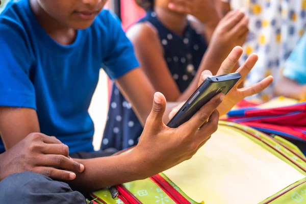 Mola sırasında okul koridorunda otururken cep telefonu kullanmakla meşgul çocukların ellerini kapat - teknoloji, sosyal medya ve akıllı telefon bağımlılığı kavramı
