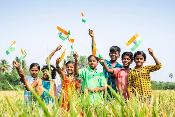 Bir grup köylü genç çocuk, Paddy dosyasına bakarak Hindistan bayrağı sallıyor. Bağımsızlık ya da cumhuriyet günü kutlaması, özgürlük ve dostluk kavramı..