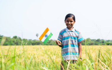 Kameraya bakarak çeltik tarlasının ortasında dikilen mutlu gülümseyen Kızılderili köylü kızı - vatanseverlik, dışlanma ya da bağımsızlık günü kutlaması ve mutluluk kavramı.