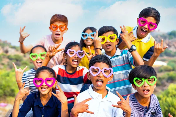Renkli gözlüklerle tezahürat yapan bir grup çocuk yaz kampı boyunca kameraya bakarak - haftasonu aktiviteleri, birliktelik ve rahatlama konsepti. — Stok fotoğraf