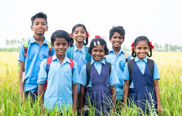Група щасливих усміхнених дітей сільської школи в уніформі, що стоїть на середньому майданчику, дивлячись на камеру концепція дружби, освіти та перемикання — стокове фото