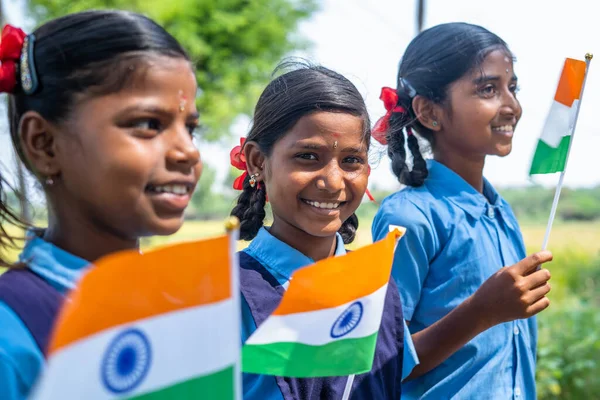 Κοντινό πλάνο του κοριτσιού με σχολική στολή κοιτάζοντας την κάμερα ενώ κρατούσε ινδική σημαία στο σχολείο - έννοια της ελευθερίας, του πατριωτισμού και της εκπαίδευσης. — Φωτογραφία Αρχείου