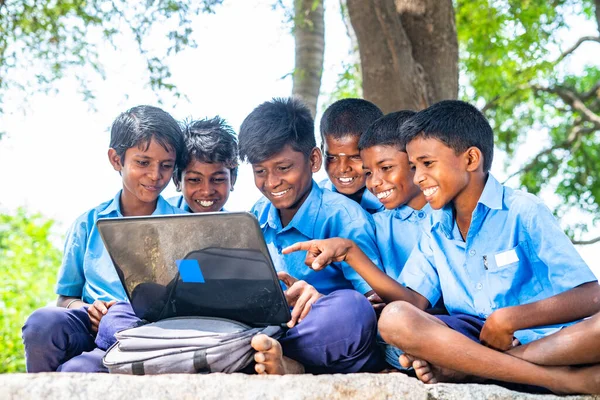 Village group of kids in uniform with using laptop while sitting on near paddy field - concept of education, development and technology. — Stock Photo, Image