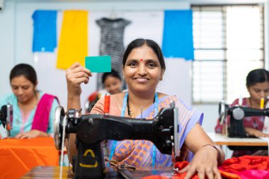 Yeşil ekran boş kartını gösteren kadınlar, dikiş dikerken kameraya bakıyorlar. Çalışan kimliği, reklam ve promosyon kavramı.