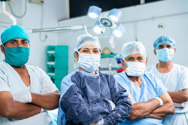 Группа хирургов, уверенно стоящих перед камерой в операционном зале - концепт здравоохранения, командной работы, экспертизы и профессиональной профессии — стоковое фото