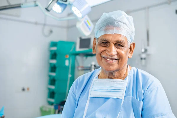 Портрет старшого усміхненого хірурга в операційному театрі в сукні - концепція досвідченого, досвідченого та медичного лікування . — стокове фото
