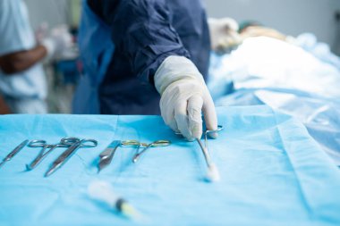 Close up shot of surgeons using medical equipment for surgery at operation theatre - concept of treatment, responsibility and professional occupation.
