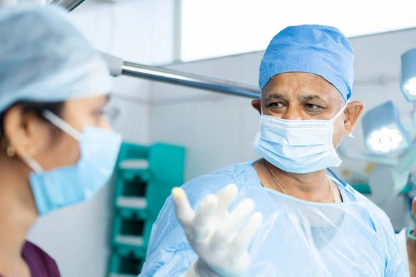 Close up shot of surgeon busy operating surgery with support staff or practitioners at operation theater - concept of profesional occupation, healthcare treatment and emergency — 스톡 사진