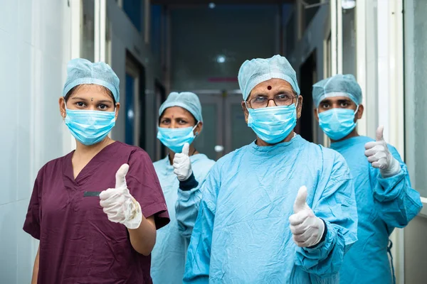 Група хірургів, що показують підпис великих пальців під час стадіонування в коридорі - затверджена, успішні професіонали з лікування та теплопостачання — стокове фото