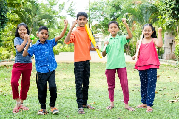 Ομάδα χαρούμενα παιδιά έφηβος κερδίζει γιορτή φωνάζοντας με ρόπαλο και μπάλα κοιτάζοντας κάμερα στο πάρκο - έννοια της επίτευξης, την ευτυχία και την επιτυχία — Φωτογραφία Αρχείου