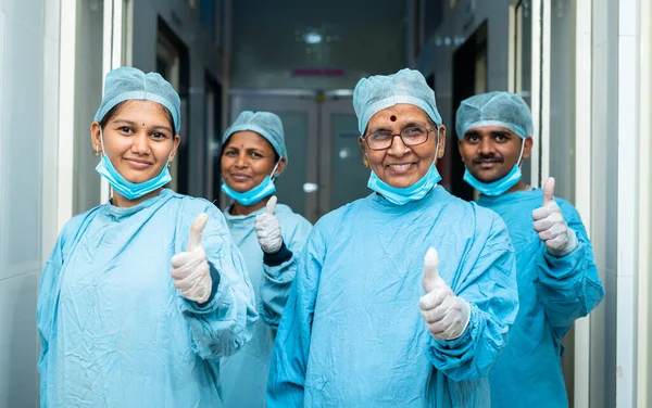 Усміхнена група хірургів, що показують великі пальці в коридорі після операції концепція успішного лікування, лікарі-практики та професіонали з теплового догляду — стокове фото