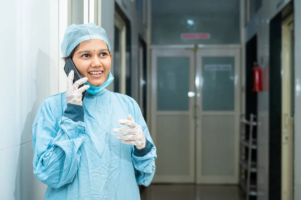 Щасливий усміхнений молодий хірург розмовляє по мобільному телефону в лікарняному коридорі після операції концепція успішного лікування, релаксації та охорони здоров'я або медичної служби — стокове фото