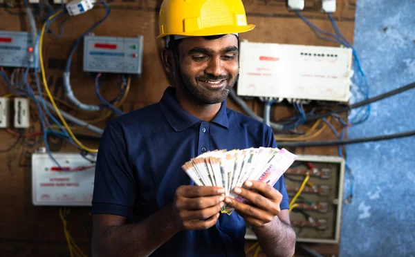 smiling electrician couting money - concept of payment after completion of work, successful career and happiness