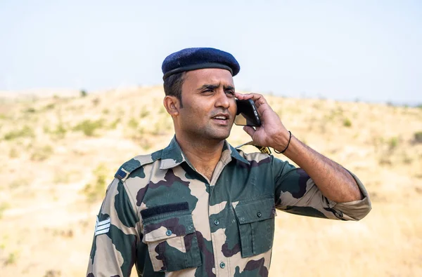 Gelukkige Indiase soldaat in uniform praten met familie - concept van dienstdoende militair, communicatie en miising familie of vrienden — Stockfoto