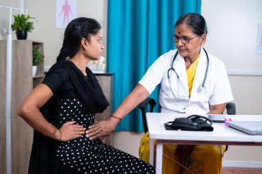 Hasta kadın hasta tedavi için hastanedeki doktora mide ağrısını açıklıyor - teşhis ve sağlık sigortası kavramı.