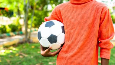 Fotokopi alanı olan bahçede futbol oynayan genç bir çocuk. Amaçlar, gelecek hedefler ve hafta sonu tatilleri kavramı..