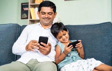 Koltukta otururken cep telefonu kullanmakla meşgul olan çocuk Young baba ve çocuğa odaklan. Teknoloji, sosyal medya ve internet kavramı..