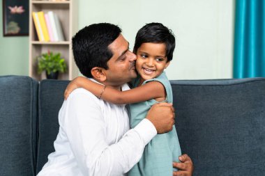 Küçük kız, evde öpüşerek babasına sarılıyor. Aşk, ebeveynlik ve uyum kavramı..